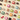 An assortment of colorful wrapped and unwrapped chocolates, fruit pieces, and candy, arranged in a diagonal grid pattern on a light beige surface.