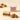 Cremino Caramel Gold 9 pcs: a bitten layered square, three creamy caramel cubes, and one elegantly wrapped chocolate. - AI generated text